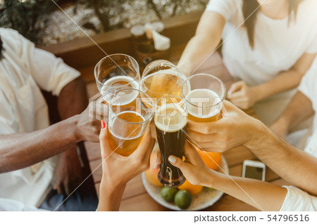 Young group of friends drinking beer and celebrating together 54796516