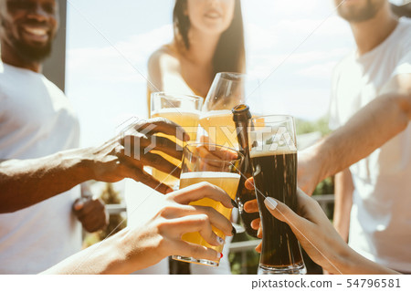 Young group of friends drinking beer and celebrating together 54796581