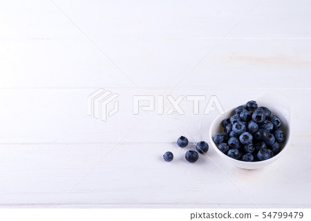 Freshly picked blueberries in bowl on white wooden background. Blueberry antioxidant. Concept for Freshly picked blueberries in bowl on white wooden background. Blueberry antioxidant. Concept for 54799479