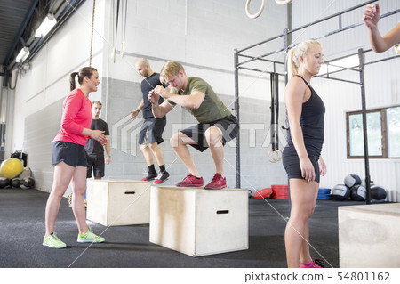 Workout group trains box jumps 54801162