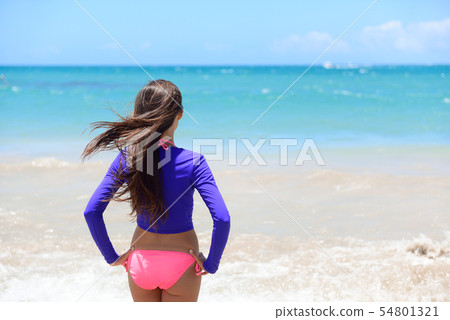 Beach girl going swimming in rash guard swim shirt 54801321