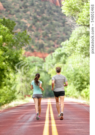 Runners running on road in nature away from camera 54801468