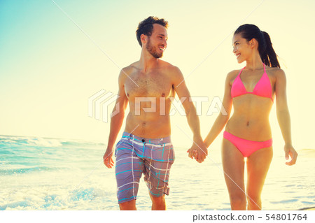 Couple holding hands together at beach sunset Couple holding hands together at beach sunset 54801764