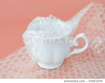 Elegant tea cup half packaged with bubble wrap 54801844