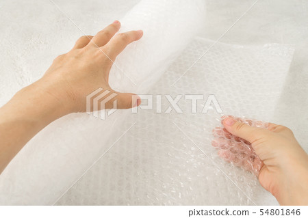 Woman hands hold a roll of transparent bubble wrap 54801846