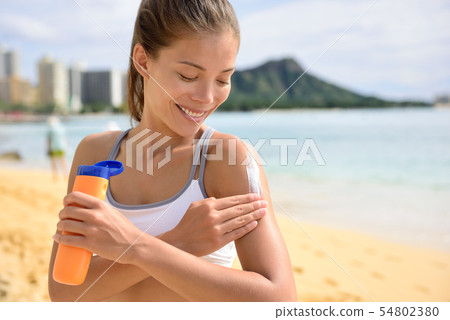 Sunscreen fitness woman applying suntan lotion Sunscreen fitness woman applying suntan lotion 54802380