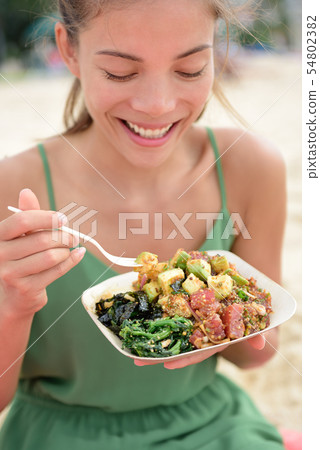 Woman eating local Hawaii food Poke bowl salad 54802382