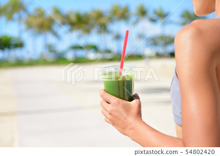 Vegetable green detox smoothie - Woman drinking 54802420