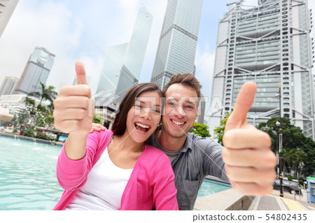 Happy thumbs up multicultural couple in Hong Kong Happy thumbs up multicultural couple in Hong Kong 54802435