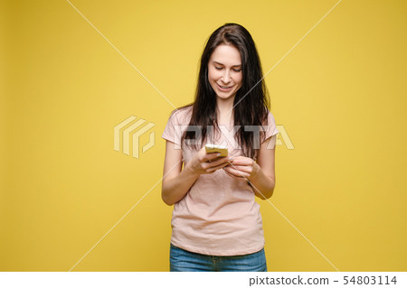 Pretty girl pointing at cell phone.Studio portrait Pretty girl pointing at cell phone.Studio portrait 54803114