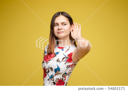 Young lady holding hand near ear and listening 54803171