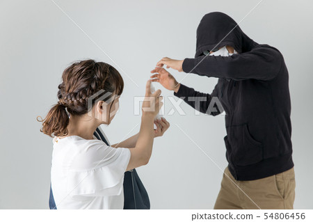 Woman applying crime spray to criminal 54806456