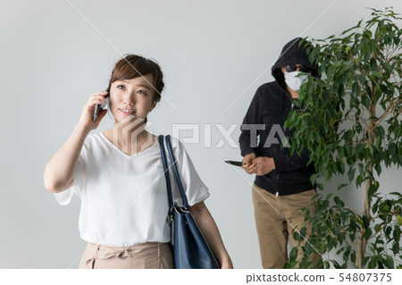 A woman who does not notice a criminal on a smartphone A woman who does not notice a criminal on a smartphone 54807375