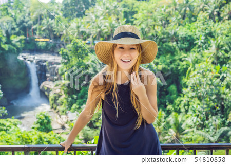Woman traveler on a waterfall background. Ecotourism concept Woman traveler on a waterfall background. Ecotourism concept 54810858