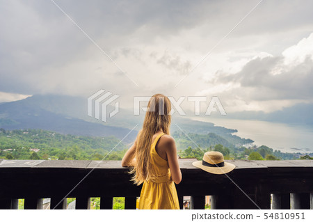 Woman traveler looking at Batur volcano. Indonesia Woman traveler looking at Batur volcano. Indonesia 54810951