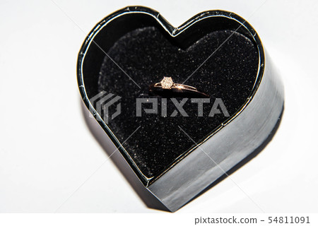 Beautiful shiny engagement ring with diamond in heart shape velvet box isolated on white background Beautiful shiny engagement ring with diamond in heart shape velvet box isolated on white background 54811091