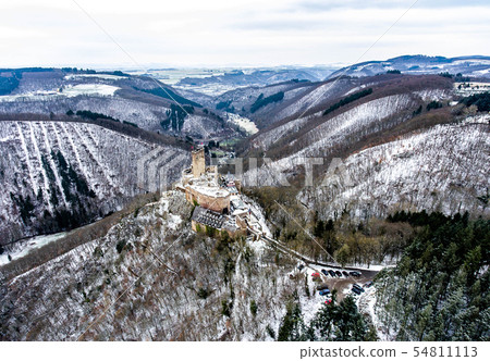 aerial view rock with medieval castle on it near moselle river in Brodenbach winter with forest snow aerial view rock with medieval castle on it near moselle river in Brodenbach winter with forest snow 54811113