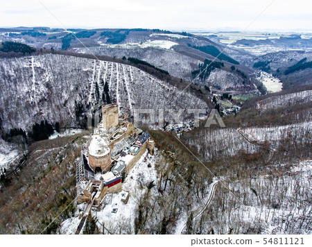 aerial view rock with medieval castle on it near moselle river in Brodenbach winter with forest snow 54811121