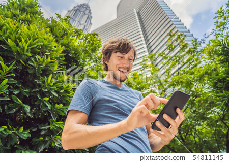 Man Tourist using navigation app on the mobile phone. Navigation map on a smartphone in a big city Man Tourist using navigation app on the mobile phone. Navigation map on a smartphone in a big city 54811145
