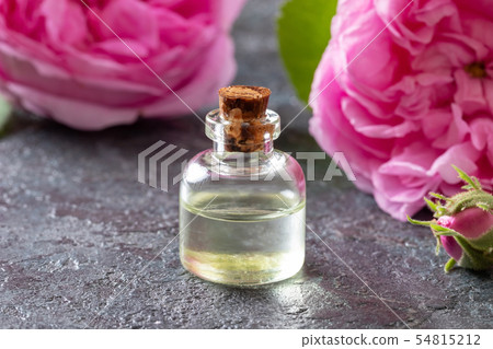 A bottle of rose essential oil with cabbage roses A bottle of rose essential oil with cabbage roses 54815212