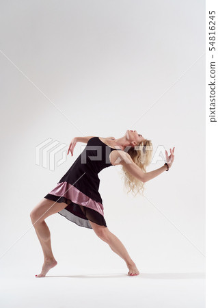 Photo of dancing girl leaning back with outstretched arm in short black dress 54816245