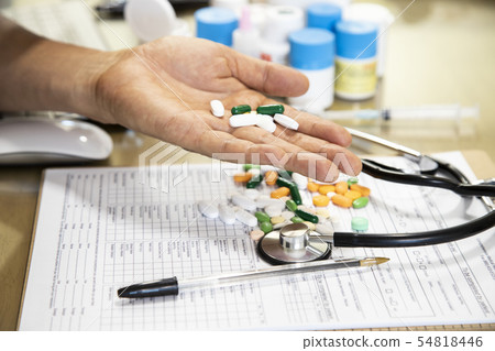 A doctor holding a pill in one hand 54818446