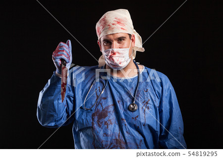 Young man dressed up in doctor costume for halloween over black background Young man dressed up in doctor costume for halloween over black background 54819295