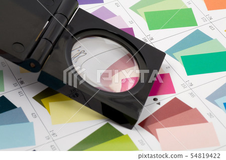 Glass loupe standing on colour swatch 54819422
