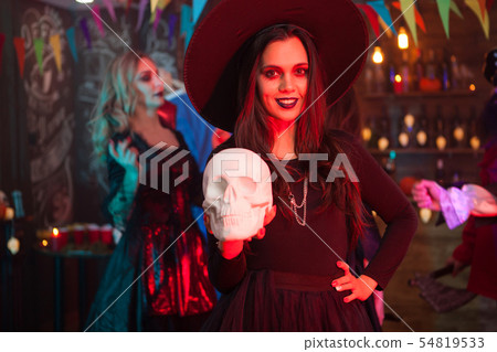 Portrait of beautiful girl with a big hat dressed up like a witch for halloween celebration Portrait of beautiful girl with a big hat dressed up like a witch for halloween celebration 54819533