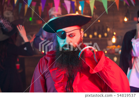 Portrait of man dressed up like pirate looking angry at the camera while celebrating halloween Portrait of man dressed up like pirate looking angry at the camera while celebrating halloween 54819537