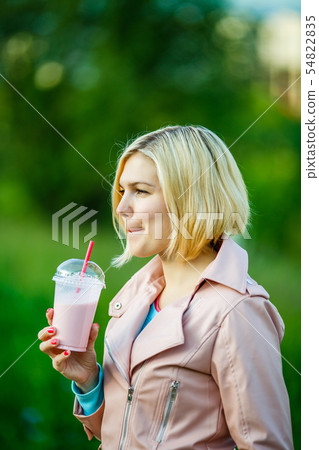 Woman in park with milkshake Woman in park with milkshake 54822835