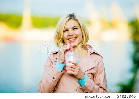 Woman with milkshake on street Woman with milkshake on street 54822840