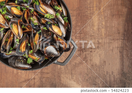 Marinara mussels cooked in a cooking pan on a rustic background Marinara mussels cooked in a cooking pan on a rustic background 54824223