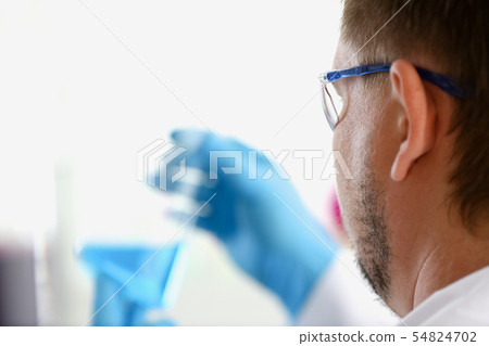 A male chemist holds test tube of glass in A male chemist holds test tube of glass in 54824702