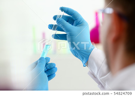 A male chemist holds test tube of glass in A male chemist holds test tube of glass in 54824709