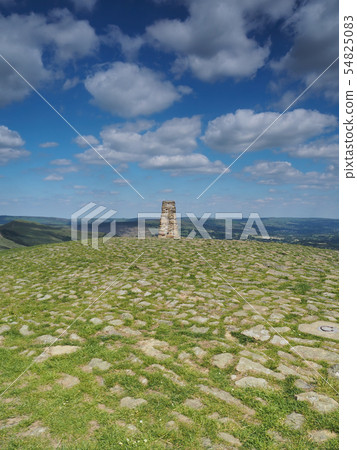 Triangulation point on Mam Tor overlooking Edale valley with white clouds, Peak District, UK 54825083