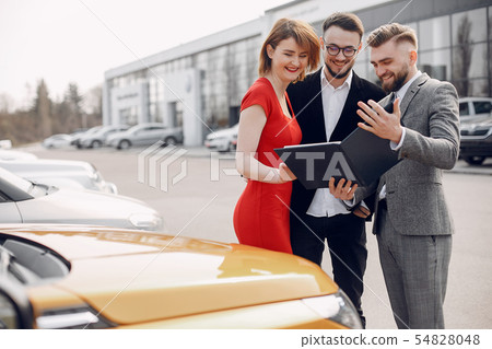 Stylish and elegant couple in a car salon Stylish and elegant couple in a car salon 54828048