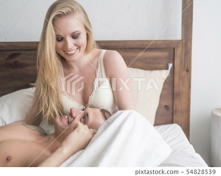 Joyful handsome boy in underwear tickles his laughing long-haired girl, lying with eyes closed Joyful handsome boy in underwear tickles his laughing long-haired girl, lying with eyes closed 54828539