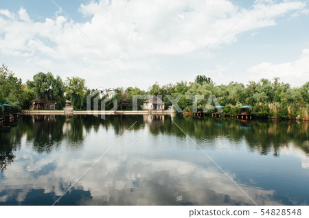 beautiful country house near the lake on a sunny day with clouds beautiful country house near the lake on a sunny day with clouds 54828548