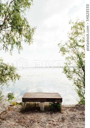 A bench with view of a lake in Summer A bench with view of a lake in Summer 54828550