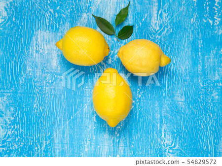 Yellow lemons on blue background. Yellow lemons on blue background. 54829572