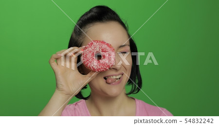 Happy beautiful young girl posing and having fun with donuts. Chroma key 54832242