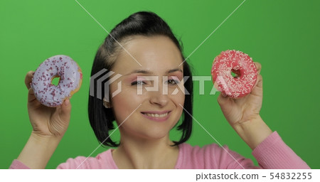Happy beautiful young girl posing and having fun with donuts. Chroma key 54832255