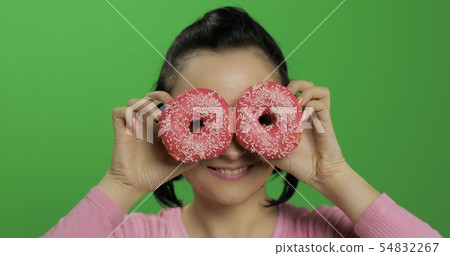 Happy beautiful young girl posing and having fun with donuts. Chroma key 54832267