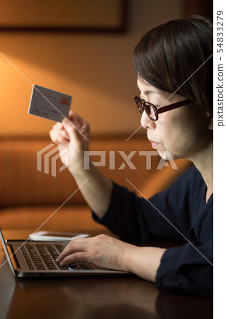 使用計算機的婦女在晚上 使用計算機的婦女在晚上 54833279