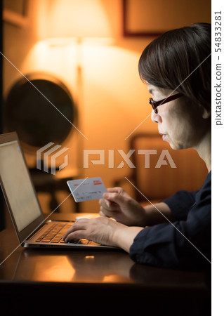 使用計算機的婦女在晚上 使用計算機的婦女在晚上 54833281