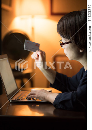 使用計算機的婦女在晚上 使用計算機的婦女在晚上 54833282