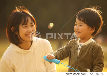 Parents and children playing with soap bubbles Parents and children playing with soap bubbles 54836190