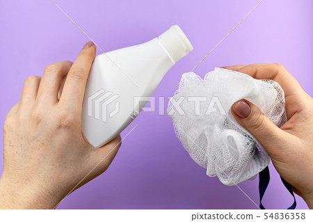 Bottle and washcloth in two hands. Bottle and washcloth in two hands. 54836358