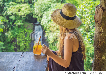 Closeup portrait image of a beautiful woman drinking ice tea with feeling happy in green nature and Closeup portrait image of a beautiful woman drinking ice tea with feeling happy in green nature and 54836363